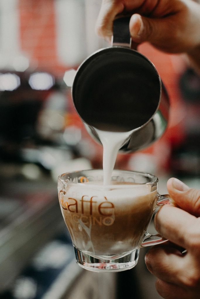 Un barista verse le lait dans un cappuccino