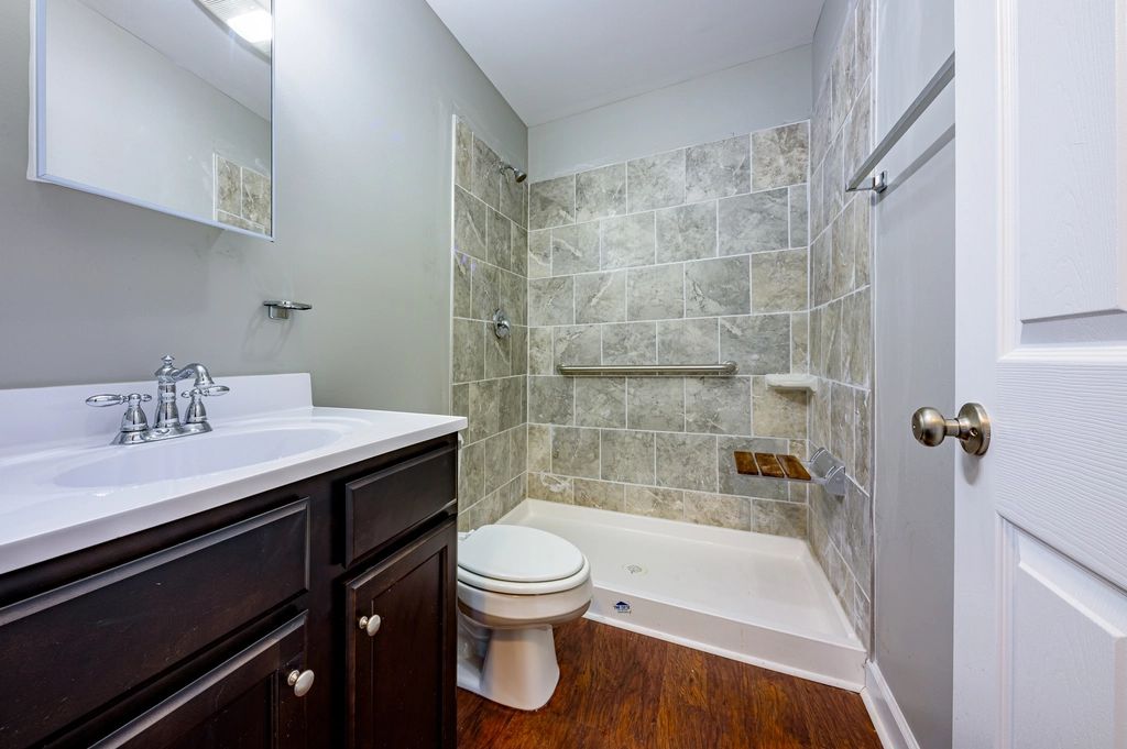 Salle de bain rénovée, douche carrelée et meuble en bois
